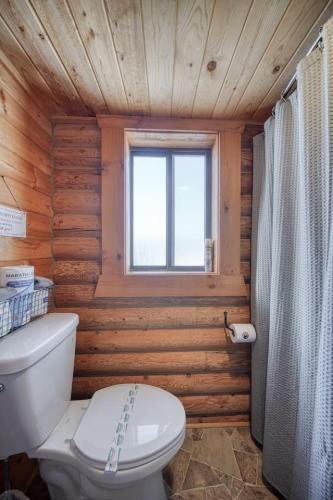 a wooden bathroom with a toilet and a window at Trout Trap at Henry's Lake in Island Park
