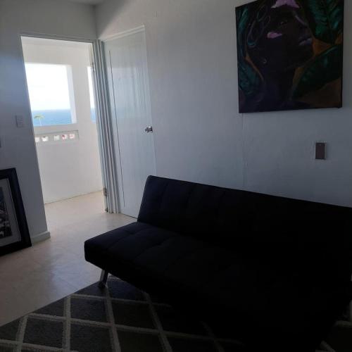 a living room with a couch and a painting on the wall at Ache Pa Ti II Isabela in Isabela