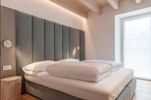 Schlafzimmer mit einem Bett mit einem großen Kopfteil in der Unterkunft COMFORT 70 in Levico Terme
