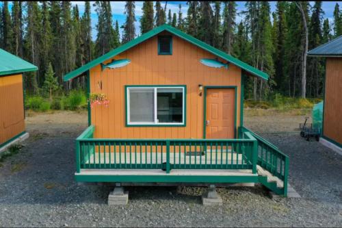 a small orange house with a green roof at Rainbow Trout Retreat, Cabin 5 at Lower Kenai Lodge in Kenai