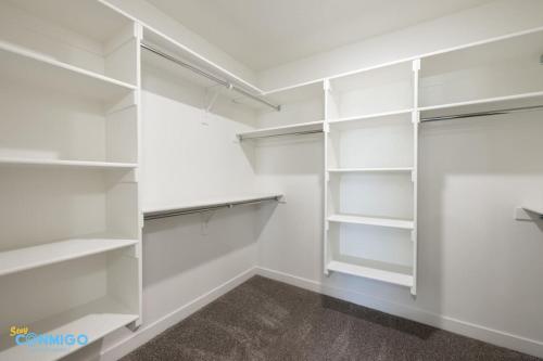 a white walk in closet with white shelves at Pooley Pad in American Fork