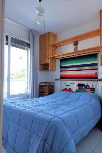 une chambre avec un lit bleu et une fenêtre dans l'établissement SUNSET Joli 3 Pièces vue mer piscine Rochelongue Cap d'Agde, au Cap d'Agde