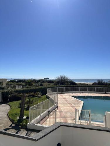 une vue sur une piscine et l'océan dans l'établissement SUNSET Joli 3 Pièces vue mer piscine Rochelongue Cap d'Agde, au Cap d'Agde