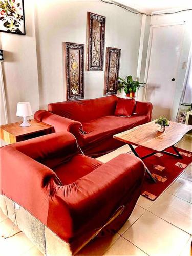 a living room with red couches and a table at 2-Bedroom/free parking/WiFi in Cainta
