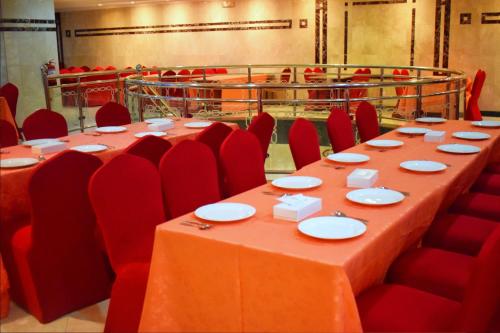 a conference room with a long table and red chairs at وفادة الزهراء in Al Madinah