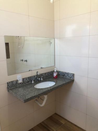 a bathroom with a sink and a mirror at Espaço céu Azul in Ribeirão Preto