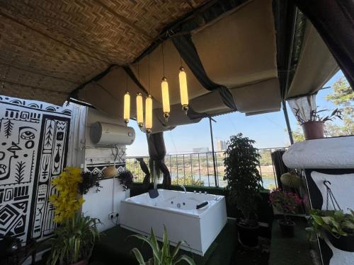 een witte wastafel in een kamer met planten bij Jacuzzi house with private terrace ambiance in Pune