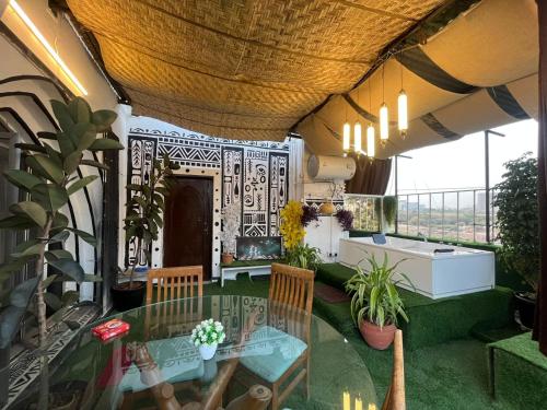 Cette chambre dispose d'une table, de chaises et d'un balcon. dans l'établissement Jacuzzi house with private terrace ambiance, à Pune