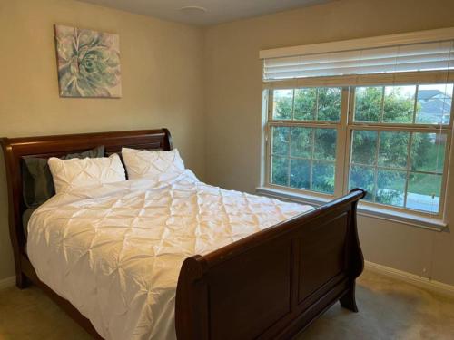 a bedroom with a large bed and a window at Lush 4BR, Large Bckyd, Hot Tub (Tal) in Helotes