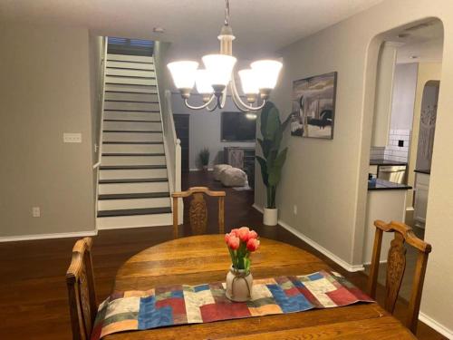a dining room table with a vase of flowers on it at Luxury 4 BR home with Pool near attractions (Cobbl.) in Helotes