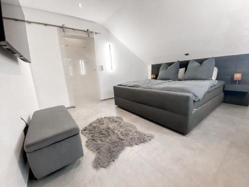 a bedroom with a bed and a chair and a rug at Moderne Wohnung mit Stadtblick in Herdecke