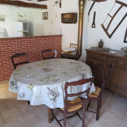 une table et des chaises dans une pièce avec une table et un comptoir dans l'établissement Les hortensias, à Biville-la-Baignarde