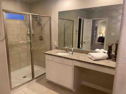 a bathroom with a shower and a sink and a mirror at Lxry 4 BR Bckyd, Pool, Hot Tub near attrctns (Tal.) in Helotes