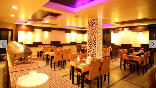restauracja ze stołami i krzesłami w pokoju w obiekcie Hotel Ganga Amrit Haridwar Near Railway Station w mieście Haridwar