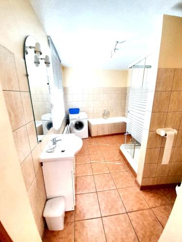 une salle de bain avec un lavabo, une douche et une baignoire dans l'établissement Maison de charme avec jardin à Ingersheim - Chaleur cosy, à Ingersheim