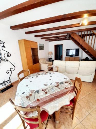 un salon avec une table, des chaises et un canapé dans l'établissement Maison de charme avec jardin à Ingersheim - Chaleur cosy, à Ingersheim