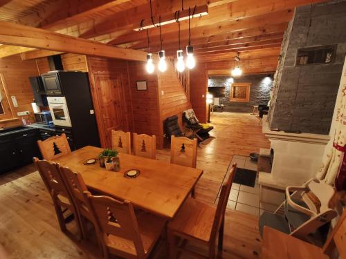 uma sala de jantar com uma mesa de madeira e cadeiras em The dream catcher -Spa- panoramic sauna- 2 MINUTES FROM THE SLOPES em La Bresse