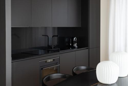 a kitchen with black cabinets and a table and chairs at Oro1 Florence Luxury Apartment by Mmega in Florence