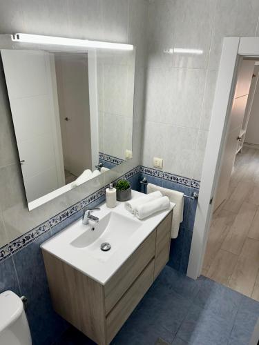 ein Bad mit einem Waschbecken und einem Spiegel in der Unterkunft Cozy flat 5 mins from the beach in Gijón
