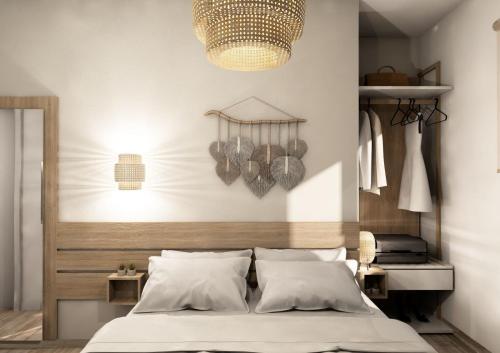 Schlafzimmer mit einem Bett und einem Kronleuchter in der Unterkunft Magdalena Seaside Apartments in Nea Roda