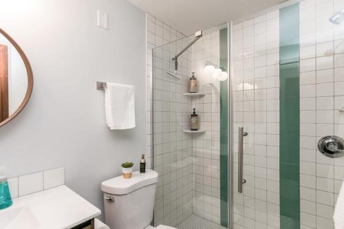 a bathroom with a shower with a toilet and a sink at Mid-Century Style And Class In Quiet NE Location in Cedar Rapids