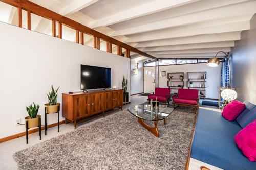 a living room with a couch and a tv at Mid-Century Style And Class In Quiet NE Location in Cedar Rapids