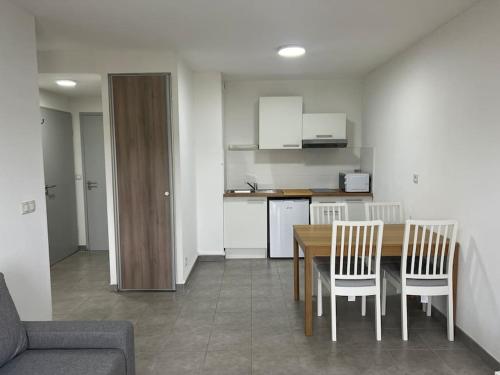 une cuisine et une salle à manger avec une table et des chaises dans l'établissement Boston, à Juvignac