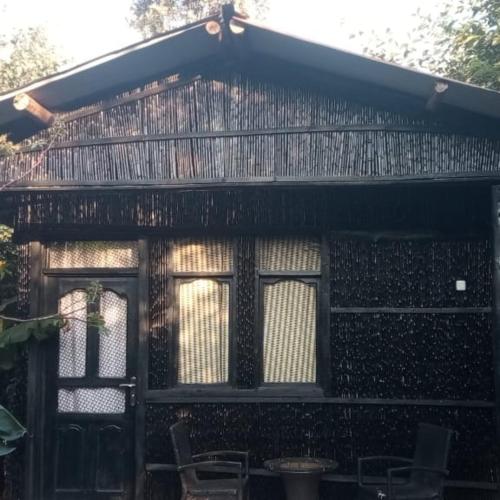 a house with a screened in porch with windows at IWACU ECO LODGE in Rwumba