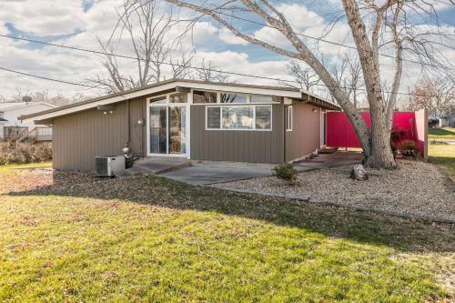 a small house with a tree in a yard at Mid-Century Style And Class In Quiet NE Location in Cedar Rapids