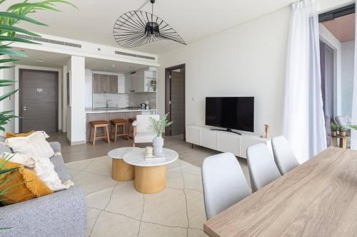 a living room with a dining room table and a kitchen at Frank Porter - One Park Avenue in Dubai