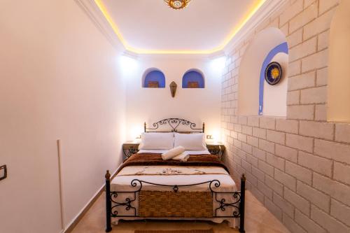 una camera con un letto in un muro di mattoni di DAR NOKHBA INN a Chefchaouen