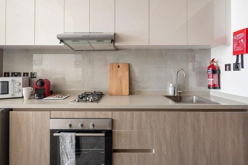 a kitchen with a sink and a stove top oven at Frank Porter - Majestique 1 in Dubai