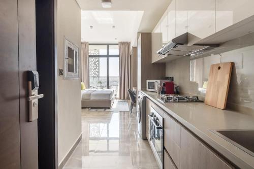 a kitchen with a counter and a living room at Frank Porter - Majestique 1 in Dubai