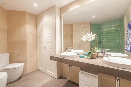 a bathroom with two sinks and a toilet at Homeclub Exclusive Flat at Madrid Tower in Madrid