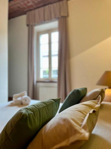 a bedroom with a bed with green pillows and a window at Residence Internazionale in Pietrasanta
