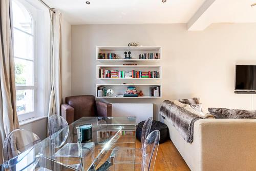 a living room with a couch and a glass table at Charming Two Bed Maisonette in Notting Hill in London