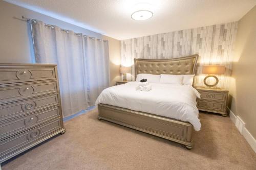 ein Schlafzimmer mit einem großen weißen Bett und einer Kommode in der Unterkunft Luxurious home, Sleeps 13, Minutes off Anthony Henday, Shopping, Restaraunts, Casino in Edmonton