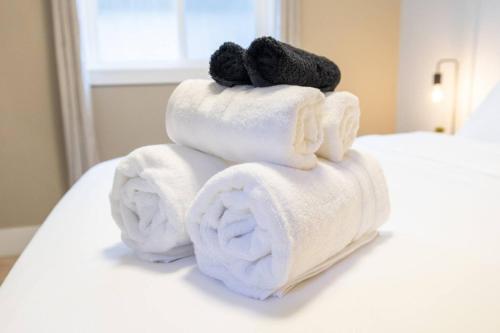 einen Stapel Handtücher auf einem Bett mit einem Teddybär in der Unterkunft Luxurious home, Sleeps 13, Minutes off Anthony Henday, Shopping, Restaraunts, Casino in Edmonton