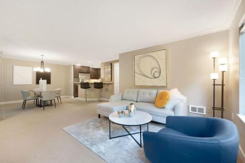 a living room with a blue couch and a table at 115 Modern and Serene Min to Downtown in Bellevue