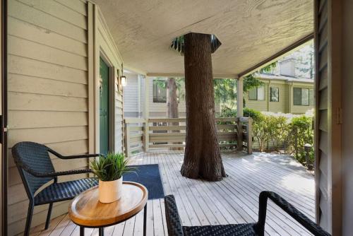 a porch with a table and chairs and a tree at 115 Modern and Serene Min to Downtown in Bellevue