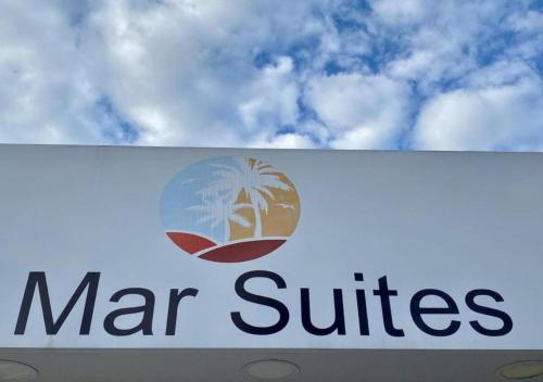 a sign for a mar suites store with a palm tree at Pousada Mar Suites Toninhas in Ubatuba