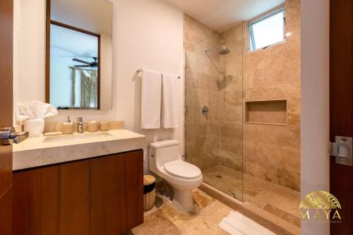 a bathroom with a toilet sink and a shower at NHOA 206A Lux 2BR Condo Jungle View in Aldea Zama in Tulum