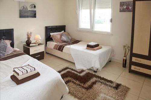 een slaapkamer met 2 bedden en een raam bij Spacious 2 Bed 2 Bath Home in one of Sides Most Popular Communities in Side