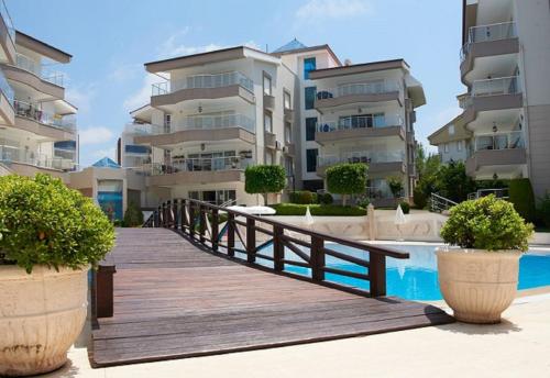 a wooden bridge over a pool in front of some buildings at Spacious 2 Bed 2 Bath Home in one of Sides Most Popular Communities in Side