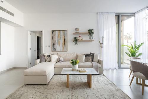 a white living room with a couch and a table at Frank Porter - Pulse C2 in Dubai