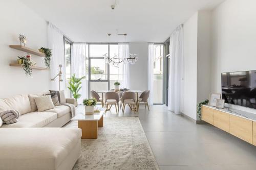 a white living room with a white couch and a table at Frank Porter - Pulse C2 in Dubai