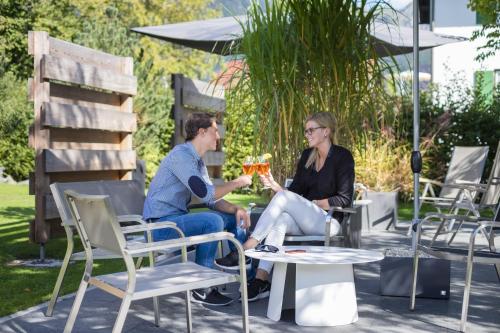 a man and a woman sitting at a picnic table at Boutique Hotel Gams in Oberstdorf