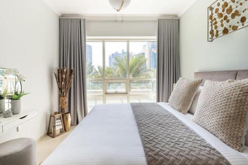 a bedroom with a large bed with a large window at Frank Porter - Al Sahab 2 in Dubai