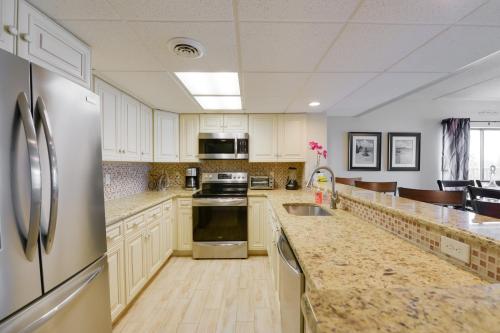 a kitchen with white cabinets and stainless steel appliances at Beautiful Brigantine Condo with Patio and Beach Access in Brigantine