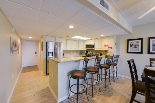 a kitchen with a bar and stools in a room at Beautiful Brigantine Condo with Patio and Beach Access in Brigantine